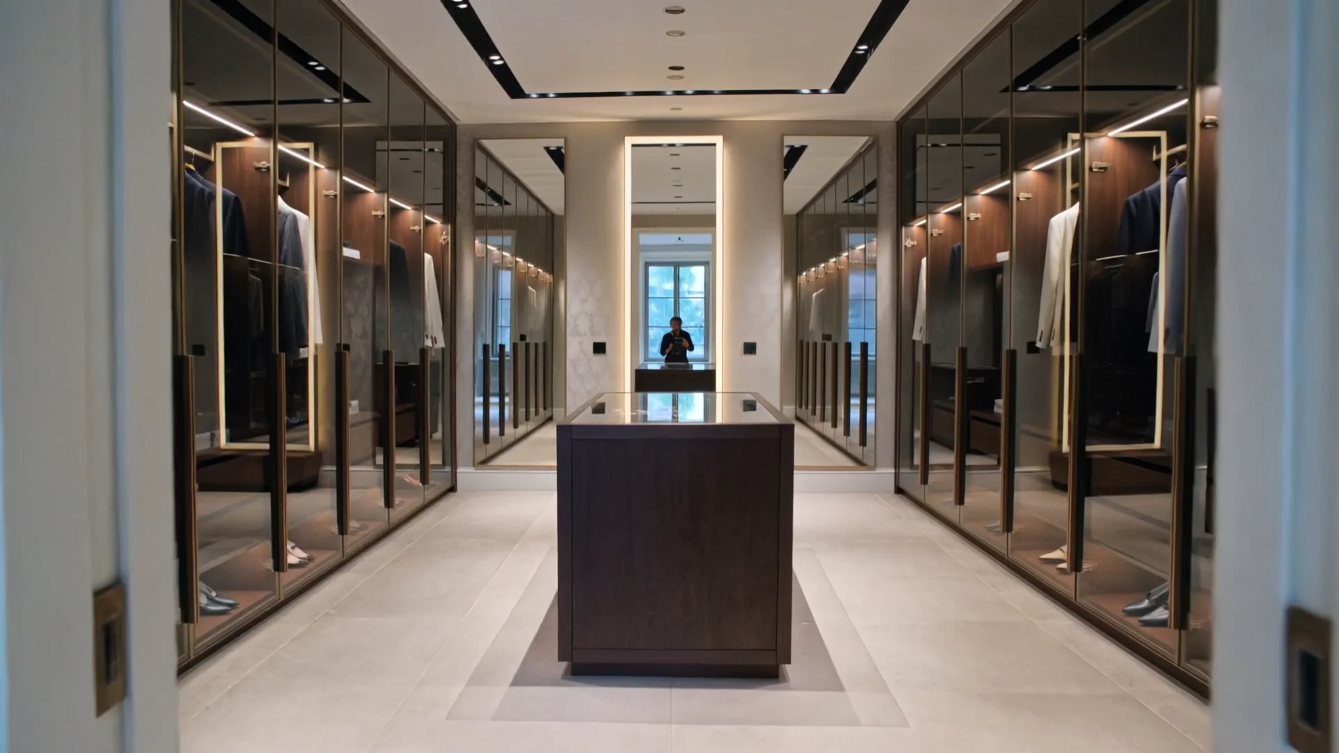 Premium walk-in wardrobe with central island, glass shutters and integrated lighting