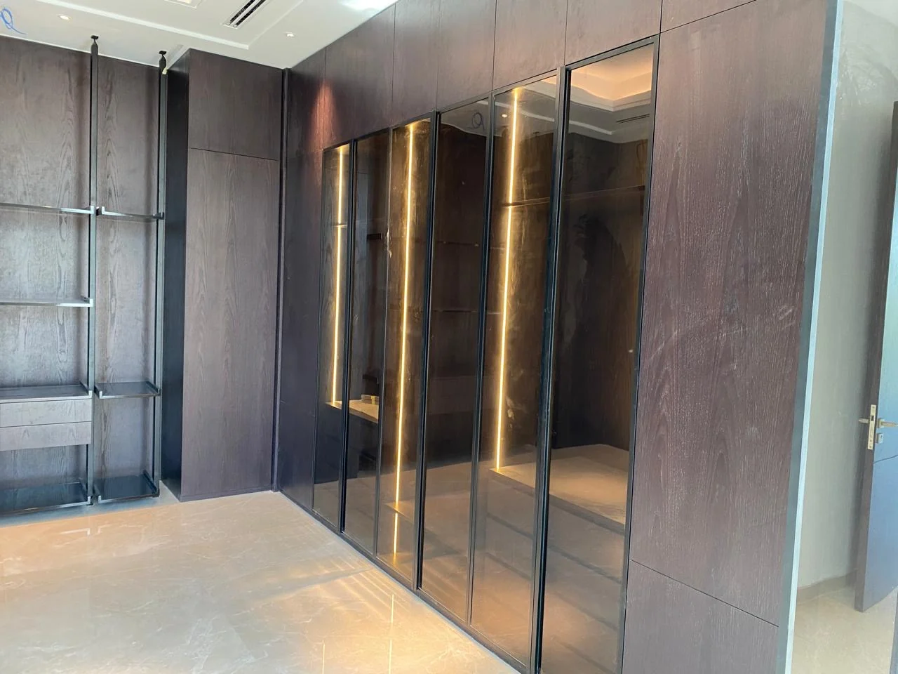 Fitted wardrobe with dark glass doors built by Time Furniture