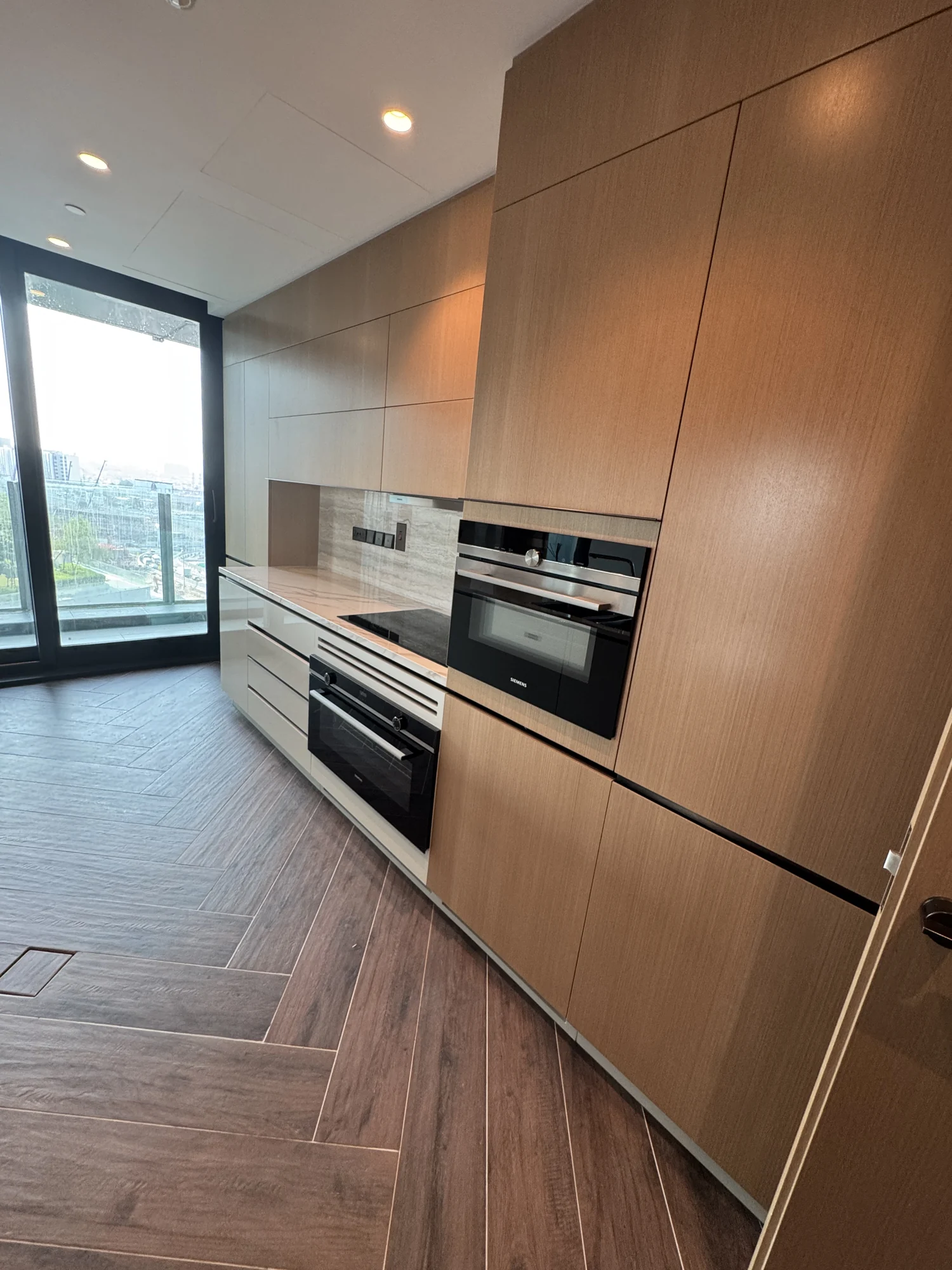 Built-in ovens integrated into warm timber kitchen cabinetry by Time Furniture