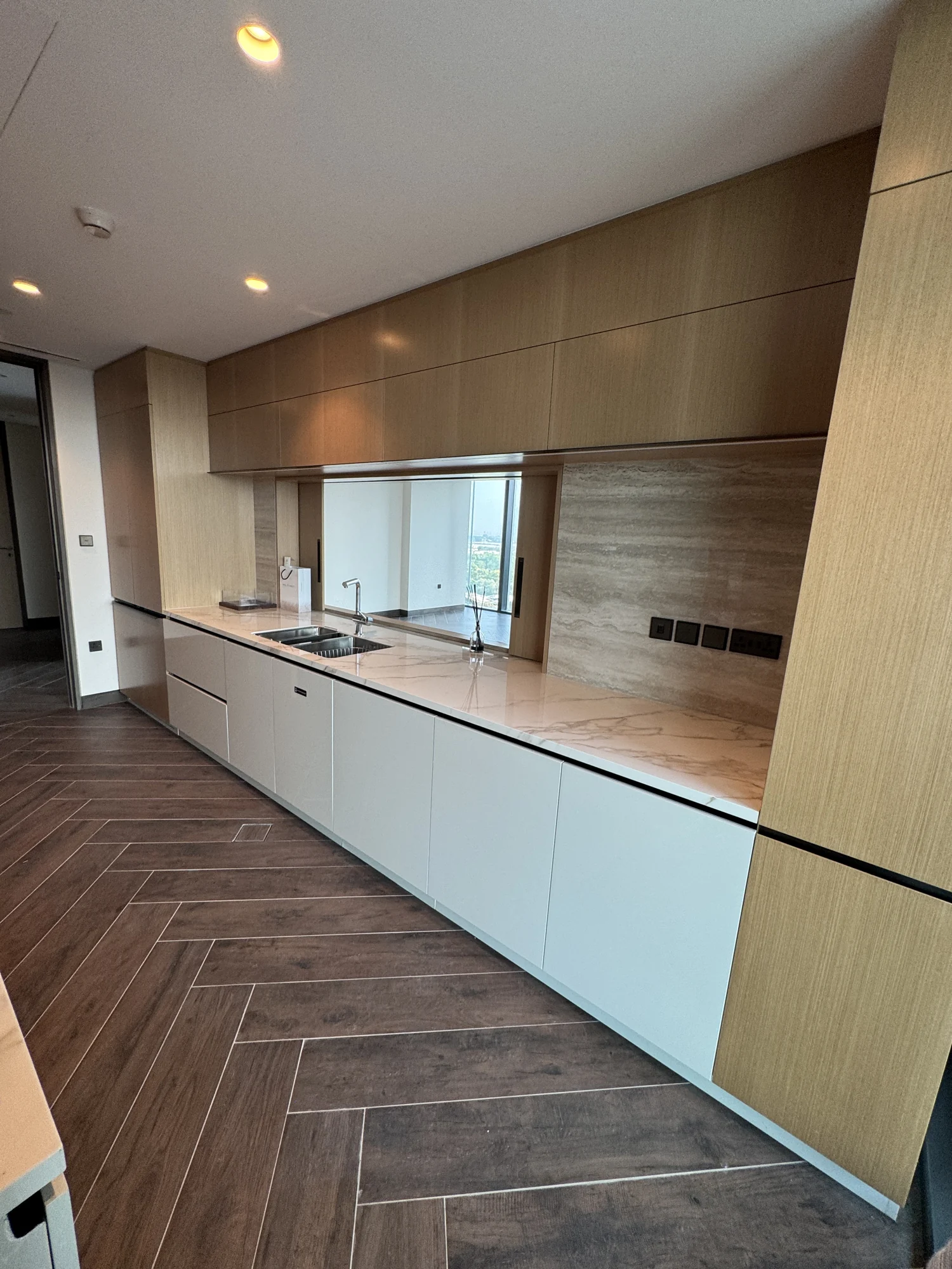 Timber kitchen wall units above pale base cabinets and a stone worktop by Time Furniture