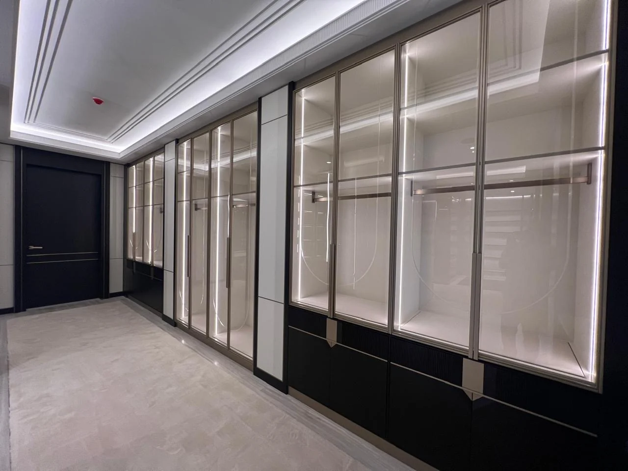 Illuminated glass-front display and storage wall built by Time Furniture