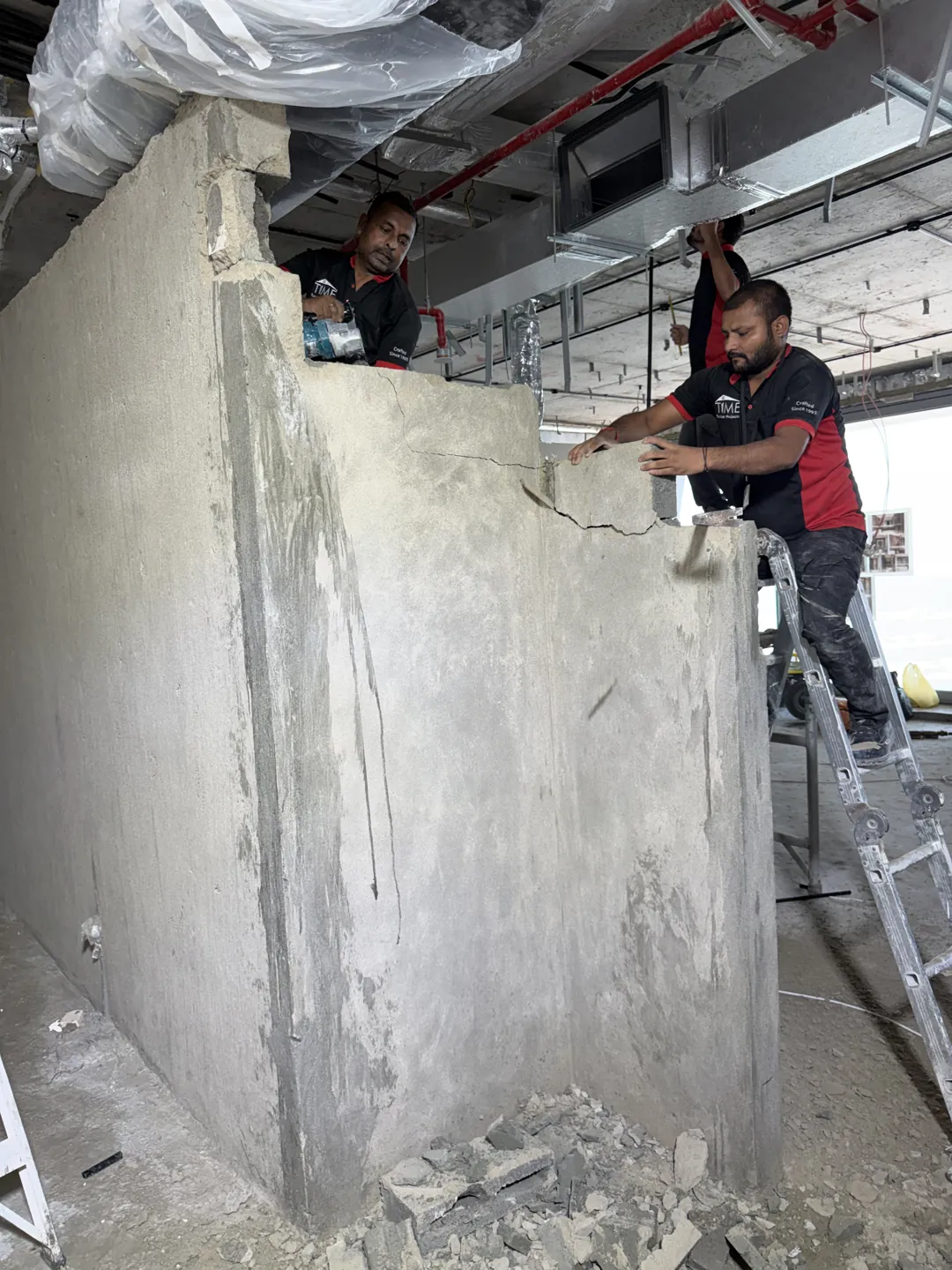 Time Furniture installer preparing an interior wall during renovation